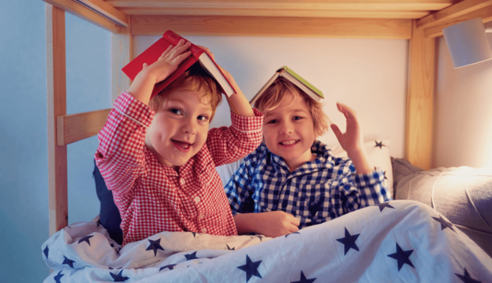 Two children playing in their bunk bed for kids